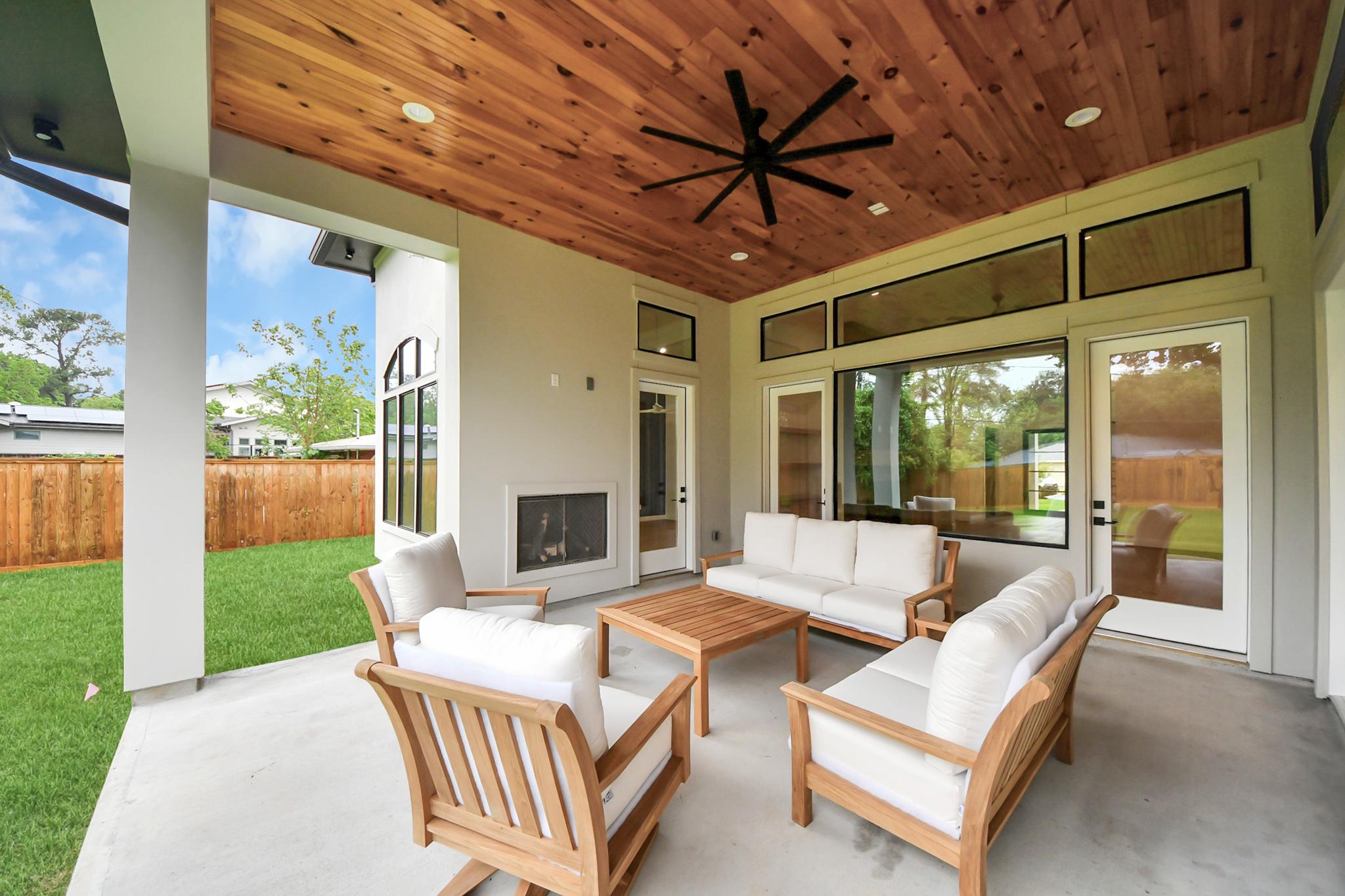 Elegant and functional covered outdoor patio with modern fireplace and outdoor kitchen in Houston, TX. Elegant and functional covered outdoor patio with modern fireplace and outdoor kitchen in Houston, TX.